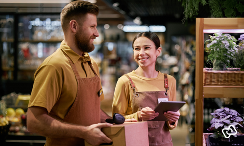 Medarbejdere i detailbutik planlægger vagtplanlægning i sommerferien med fokus på bemanding, arbejdstider og effektiv tidsregistrering