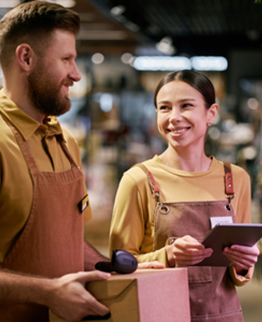 Medarbejdere i detailbutik planlægger vagtplanlægning i sommerferien med fokus på bemanding, arbejdstider og effektiv tidsregistrering