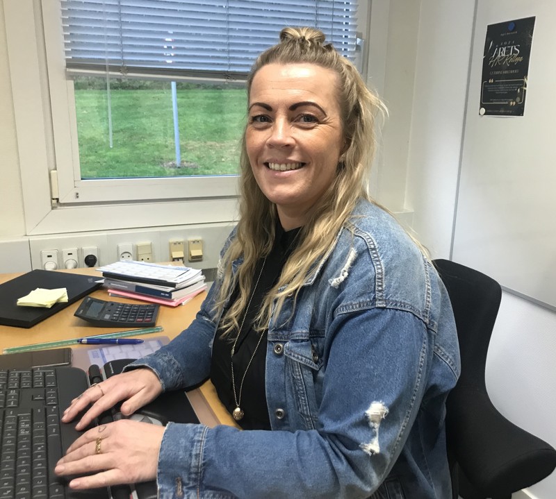 Medarbejder registrerer arbejdstid og opdaterer vagtplan på computer. Effektiv tidsregistrering og vagtplanlægning skaber overblik og sikrer korrekt lønudbetaling.