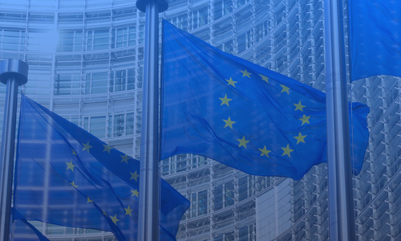 EU-flag foran en bygning i Bruxelles som symbol på EU’s direktiv om løngennemsigtighed, ligeløn og krav til lønrapportering og lønstruktur i HR-systemer.