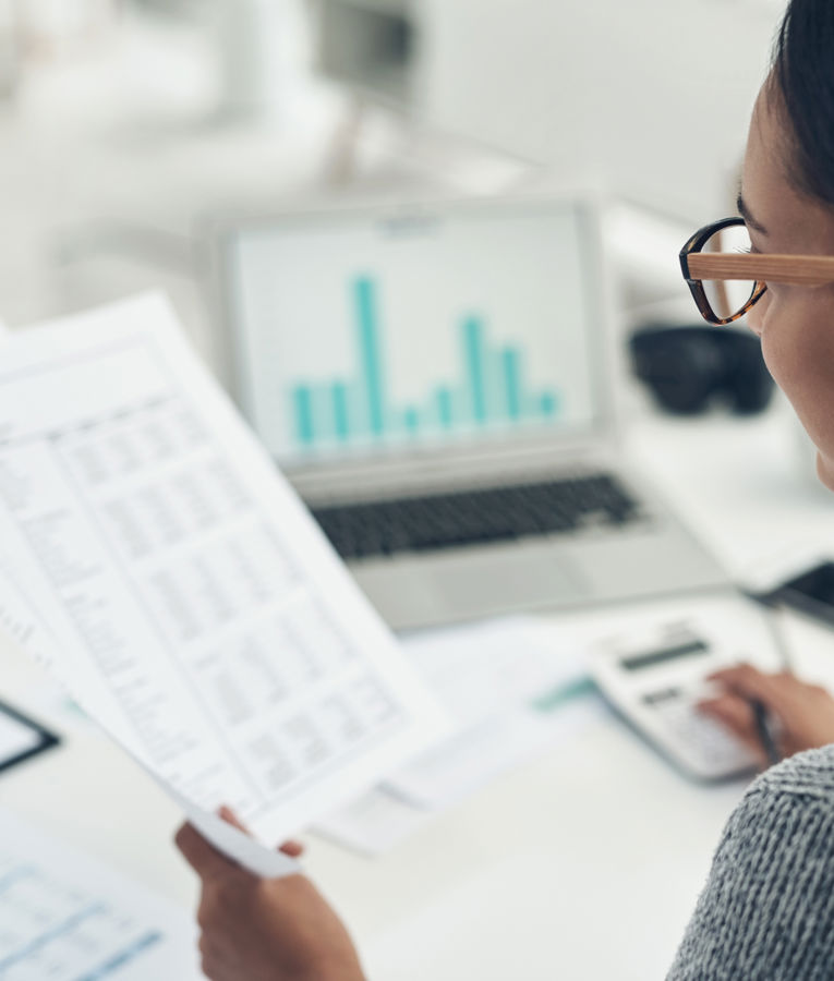 HR-medarbejder analyserer rapporter og grafer på laptop som led i workforce management, HR controlling, vagtplanlægning og tidsregistrering