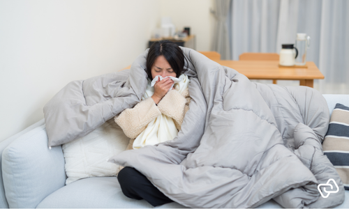 Medarbejder ligger syg i sengen og melder fravær, hvilket understreger behovet for effektiv vagtplanlægning, fraværsstyring og tidsregistrering i workforce management