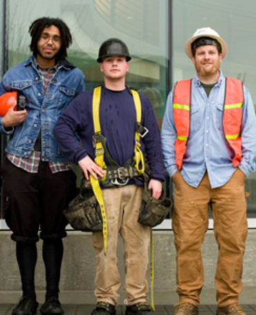 Gruppe af medarbejdere i forskellige roller og sikkerhedsudstyr, som illustrerer behovet for præcis vagtplanlægning, bemandingsstyring og effektiv workforce management på tværs af teams.