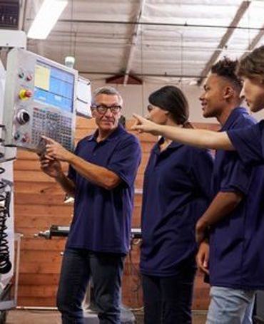 Elever og lærlinge i produktion får praktisk oplæring ved maskine under hensyntagen til gældende regler for arbejdstid og vagtplanlægning for unge medarbejdere