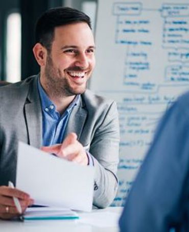 Smilende leder gennemgår ansættelsesvilkår med kandidat under jobsamtale, med fokus på EU’s løngennemsigtighedsdirektiv, fair løn, gennemsigtige lønrammer og en struktureret ansættelsesproces understøttet af workforce management.