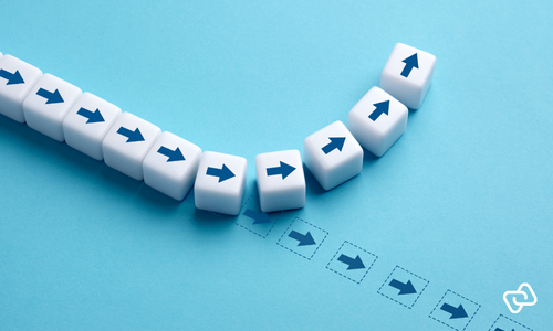 Illustration af små klodser med pile, hvor én klods skifter retning, som symbol på øget løngennemsigtighed, gennemsigtige lønstrukturer og datadrevet HR-styring.